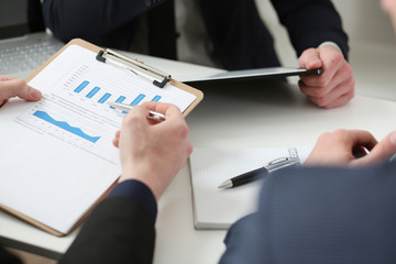 Male hands hold clipboard pad with financial statistics at office workspace closeup. White collar check money papers, stock exchange market, internal Revenue Service inspector, earning list concept