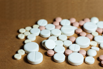 Fototapeta na wymiar Heap of white pills, tablets, capsules on yellow orange background. Drug prescription for treatment medication health care concept wth copy space.