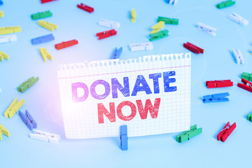 Writing note showing Donate Now. Business concept for to give something like money or goods to a...