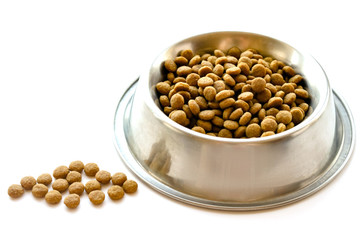 Cats and dogs dry food in metal stainless steel bowl isolated on white color background close up side view. Selective soft focus. Shallow depth of field. Text copy space. Feeding pet concept