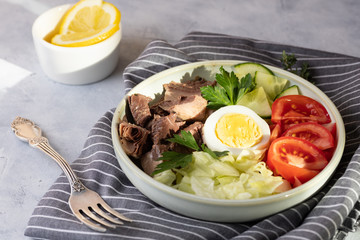 Salad with canned tuna, egg and vegetables - tomatoes, cucumber and lettuce.