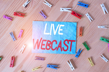 Text sign showing Live Webcast. Business photo text the process of video broadcasting live over the internet Colored clothespin papers empty reminder wooden floor background office