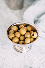 Ripe olives when serving the table. A saucer of yellow olives in the restaurant.