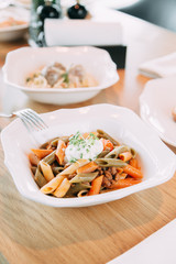 Pasta with cutlets and tomato sauce. Macaroni with meat and spices in the restaurant.