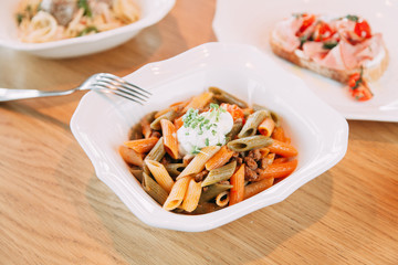 Pasta with cutlets and tomato sauce. Macaroni with meat and spices in the restaurant.