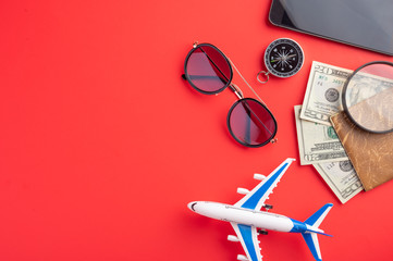 Sunny mood, time for travel and relaxation. Against a red background, an airplane, a compass,...