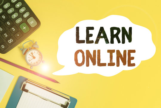 Handwriting text Learn Online. Conceptual photo education that takes place over the Internet or computer Alarm clock wakeup calculator pencil clipboard notepad color background