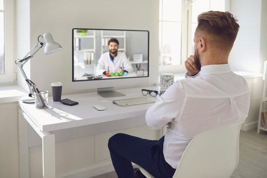 Online doctor.A man talking to a doctor online on a computer on a desk in an office. Online medical consultation.