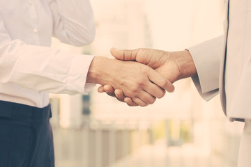 Business professionals shaking hands. Business man and woman in office clothes meeting outside. Greeting gesture concept