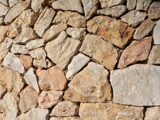 Stone wall of fortress made from broken rocks.