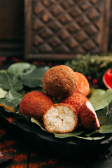 Balls of goat cheese in red pepper. Homemade natural hard cheese on a plate. Farm diet products.