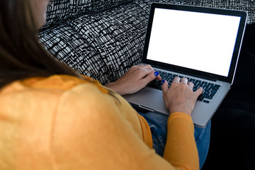 Girl teleworking on the couch, laptop with a blank screen