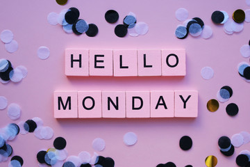 Hello monday words wooden cubes on a pink background