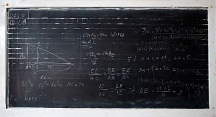 Maths formulas written by white chalk on the blackboard background.