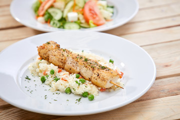 chicken kebab with rice and salad on the wooden background