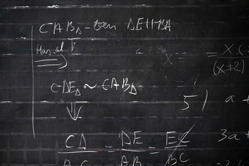 Maths formulas written by white chalk on the blackboard background.