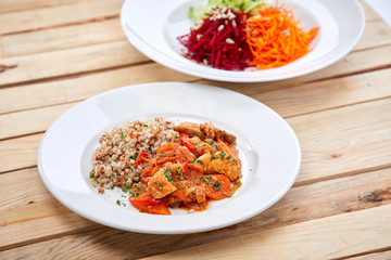 meat with buckwheat and salad on the wooden background