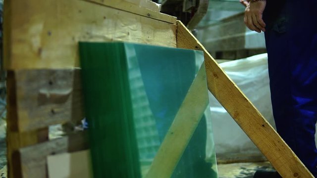 Clip of operator working in a glass manufacturing industry manufacturing and processing of ESG glasses. Close up.