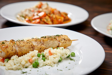 chicken kebab with rice and vegetables on the wooden background