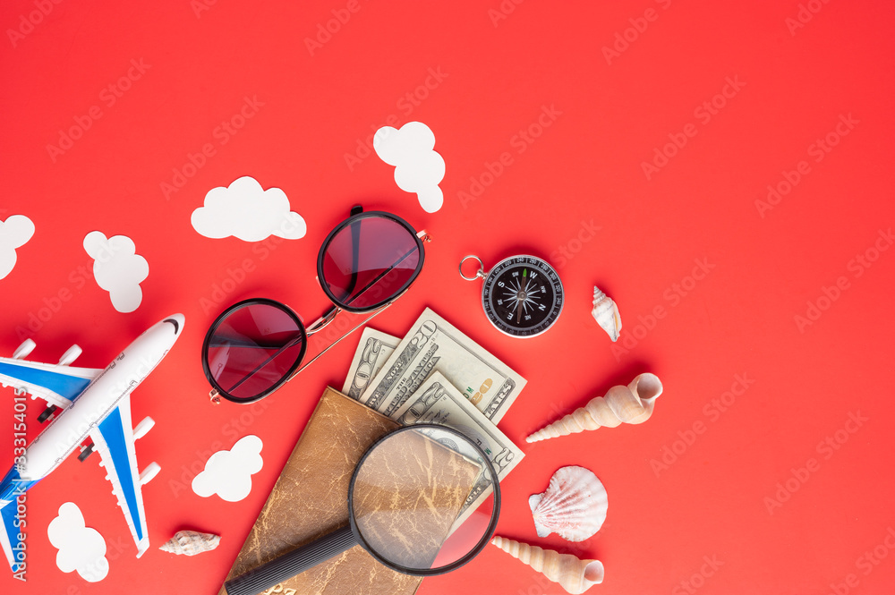 Wall mural travel and vacation. red background, summer mood. airplane, compass and passport with money. with sp