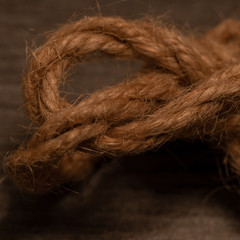 close up of a light brown rope string on brownback ground