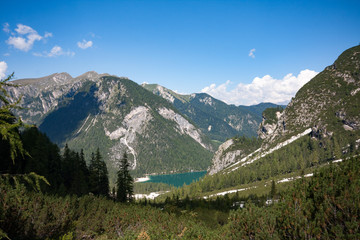 Fototapeta na wymiar Panorama of Braies Lake in Dolomites mountains, Alps mountain chain, Trentino Alto Adige region, Sudtirol, Italy. Beautiful Alpine lake Lago di Braies in sunny day