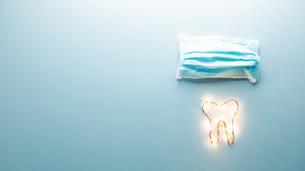 Concetto di medico dentista privato. Simbolo del dente con mascherina e stetoscopio. Panoramica con sfondo blu. Vista alto, livello piatto. Banner.