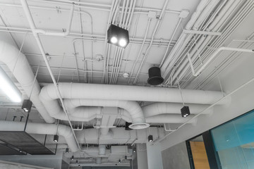 Large white pipes inside the building. modern electric system and air system in the building.