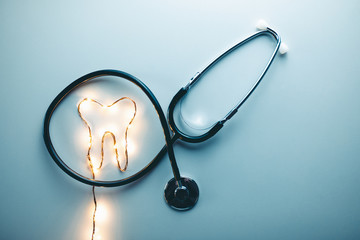 Concetto di medico dentista privato. Simbolo del dente con mascherina e stetoscopio. Vista alto...