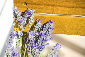 Lavender flowers close up. A bouquet of lilac flowers. Top view of a bouquet of lavender lying on a brown wooden surface. Natural daylight sunlight. Selective focus image. Copy space.