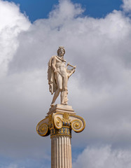 Apollo statue the ancient greek god of music and poetry under cloudy sky, Athens Greece