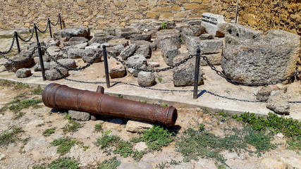 old cannon in a stone castle near stones