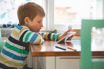 Young Boy Looking at Digital Tablet	
