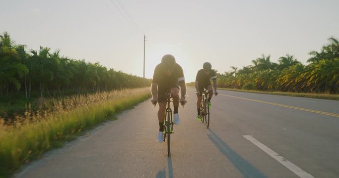 Two Male cyclist biking at sunset