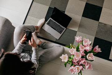 Frame above of working woman at home on quarantine with laptop and smartphone on background of...