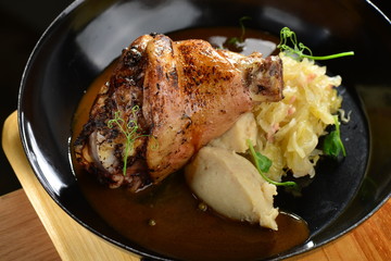 Baked shank and mashed potatoes on a plate closeup
