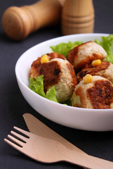 Chicken cutlets with lettuce in a white plate on a black background