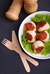 Chicken cutlets with lettuce in a white plate on a black background