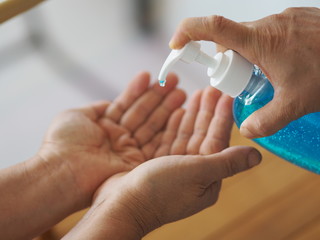 woman's hand is pressing the bottle of the alcohol gel pump give to another hand, for cleaning dirty to prevent germs protect colona virus, covid 19