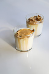 South Korean coffee dalgona – trendy cold latte or cappuccino with milk and cane sugar. Summer drink for breakfast
