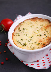 Potatoes casserole in white form on a black background,