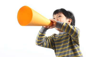 Portrait Of Little Asian Boy Talking On Megaphone Against White Background