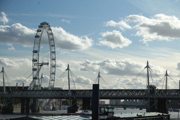 London Hungerford bridge and London Eye blue sky with fluffy clouds