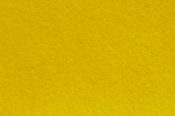 Obraz premium Yellow felt background. Surface of fabric texture.