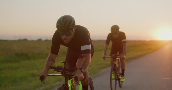 Two Male cyclist biking at sunset