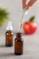 A female hand holds a dropper from a dropper bottle. Beauty concept. Natural oils. Spa care.