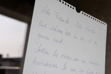 Die Inhaberin eines Geschäftes informiert ihre Kunden mit einem Zettel an der Tür über die...