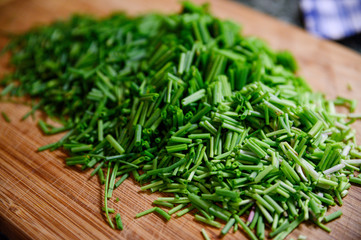 Fresh green chive chopped on wooden table