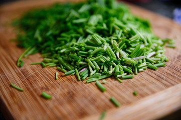 Fresh green chive chopped on wooden table