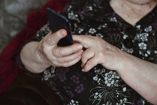 Beautiful hands of a old woman. Old woman's hands with wrinkles touching screen her smartphone